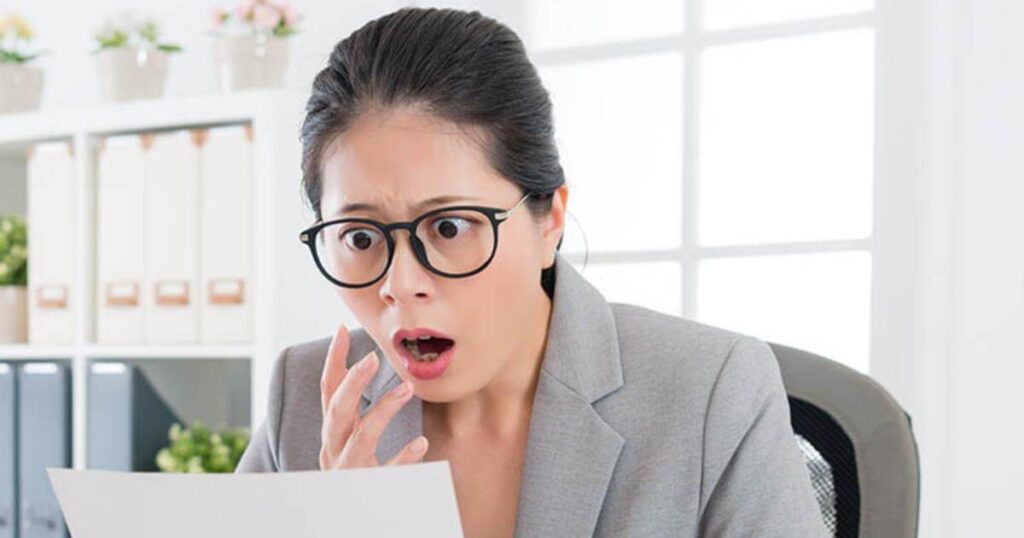 female professional looking at computer screen in shock