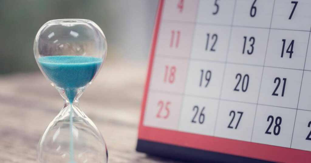 hourglass next to a calendar indicating slow time to hire